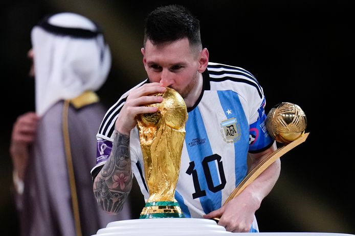 Messi, met in zijn linkerhand de trofee van beste speler van het WK, kust de wereldbeker.