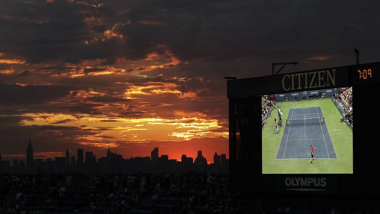 Terwijl Andy Murray en Rafael Nadal (rechts op een groot scherm) de halve finale van de US Open afwerken, gaat op de avond voor 9/11 de zon onder in New York. Beeld ap