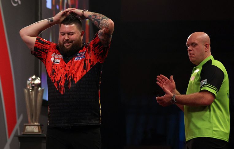 Michael van Gerwen klapt voor de nieuwe wereldkampioen darts Michael Smith. Beeld AFP