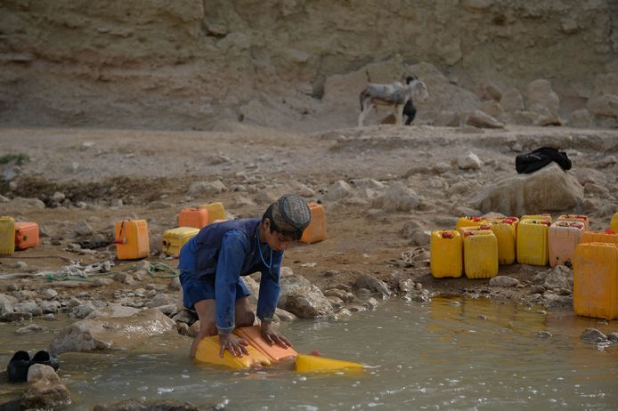 Een kind vult een jerrycan met water in Afghanistan.