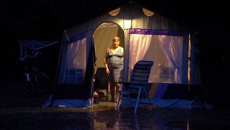 Een gast van camping Wega bij Weert bij de ondergelopen tent. Beeld ANP