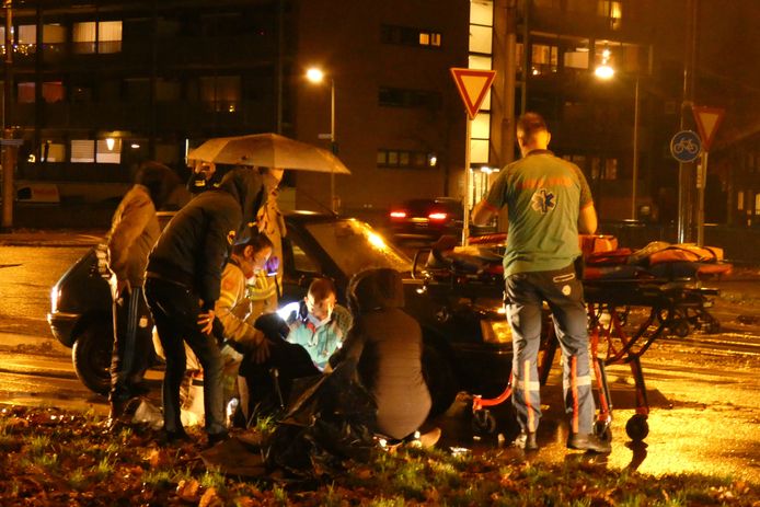 De gewonde voetganger wordt door ambulancepersoneel behandeld op de Huissensestraat in Arnhem.