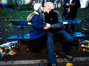 Peggy Vroman en haar echtgenoot kussen elkaar op het bankje waar 80 jaar geleden Leo Vroman zijn vrouw Tineke Sanders  voor het eerst een zoen gaf.