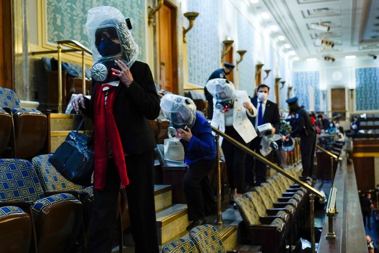 Tijdens de bestorming van het Capitool moesten politici en medewerkers in gasmaskers schuilplaatsen opzoeken. Beeld AP