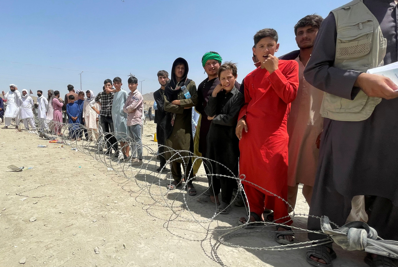 Mensen wachten in de buurt van Hamid Karzai International Airport in Kaboel.
