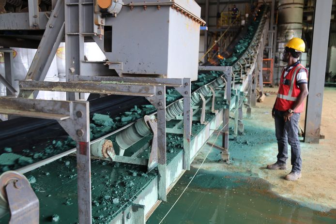 Illustratiebeeld. Een werknemer aan een lopende band met stukjes ruw kobalt na een eerste verwerking in een fabriek in Congo, voordat het wordt geëxporteerd naar voornamelijk China om verder te worden verfijnd.