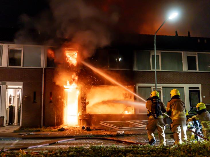 Vrouw zwaargewond en grote woningbrand na explosie in Oosterhout, voorpui ligt op straat