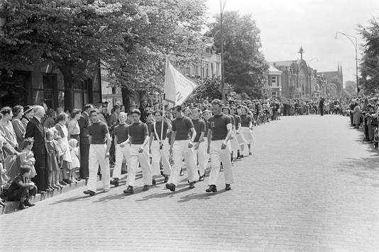Intocht van de wandelaars in de Molenstraat, tijdens de ' Oss Voorwaarts'-wandeltocht op 11 mei 1952. Op de achtergrond de gesloopte Koekfabriek en Paterskerk.