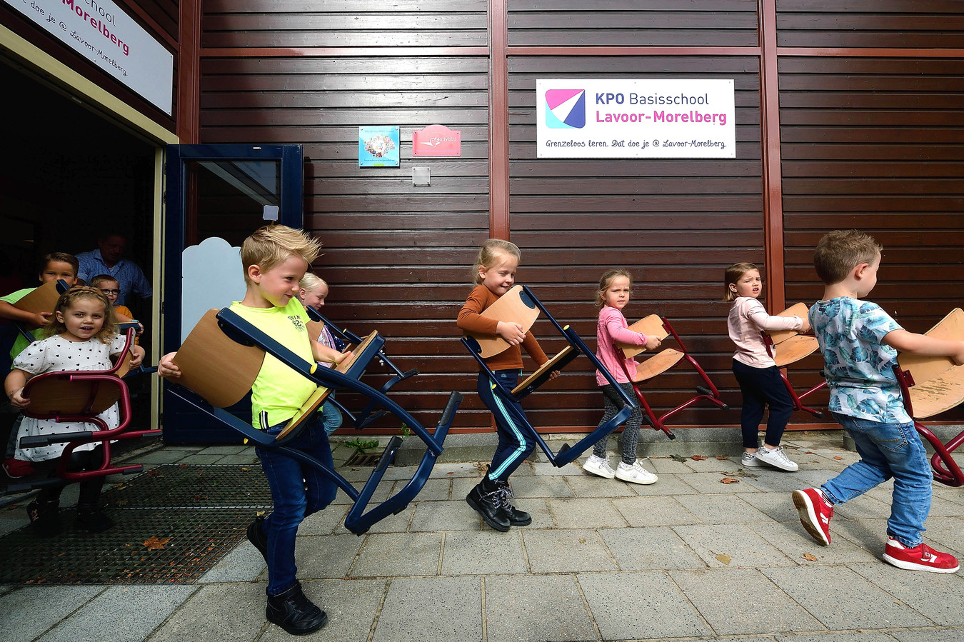 Leerlingen van basisschool Lavoor in Roosendaal dragen hun stoeltjes naar buiten, want ze krijgen nieuw schoolmeubilair
