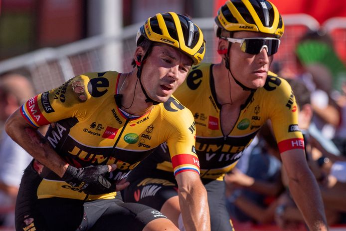 Primoz Roglic (l) wordt door Mike Teunissen over de finish geholpen.