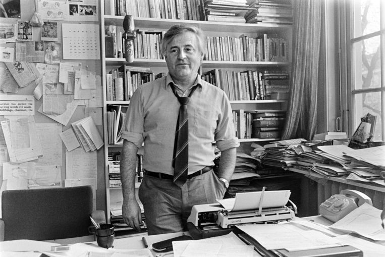 Portret van Rinus Ferdinandusse in 1983 als hoofdredacteur van Vrij Nederland achter zijn bureau met kranten, paperassen en een typemachine. Beeld ANP / Bert Verhoeff
