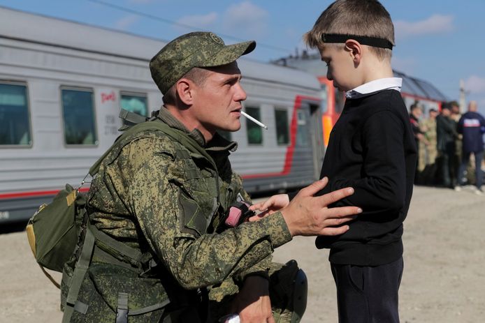 Een rekruut praat met zijn zoon voor hij op een trein stapt in Prudboi.