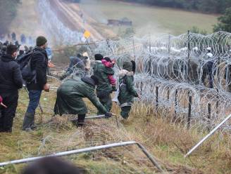 Tientallen migranten breken door hek aan grens met Polen