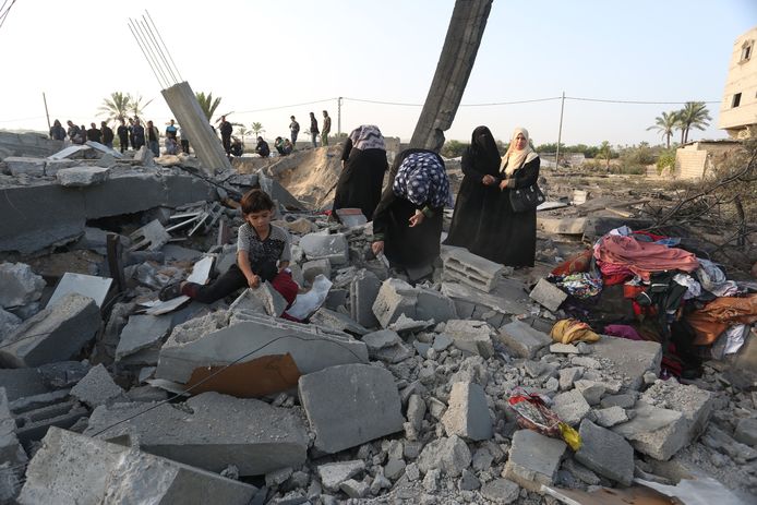 Palestijnse gezinnen bekijken de schade van een gebombardeerd huis in Khan Yunis in de Gazastrook.