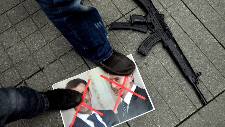 Syrische demonstranten staan op foto's van de Russische president Medvedev en premier Poetin, omdat Rusland wapens levert aan het regime van Assad. Beeld EPA