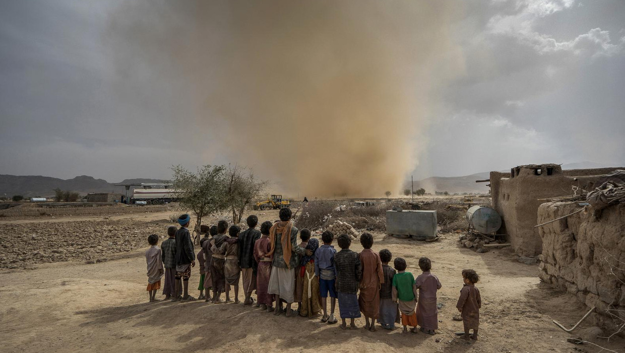 Kinderen kijken naar een kleine tornado in de woestijn in Jemen, 80 kilometer ten noorden van de hoofdstad Sanaa Beeld Giles Clarke / Getty 