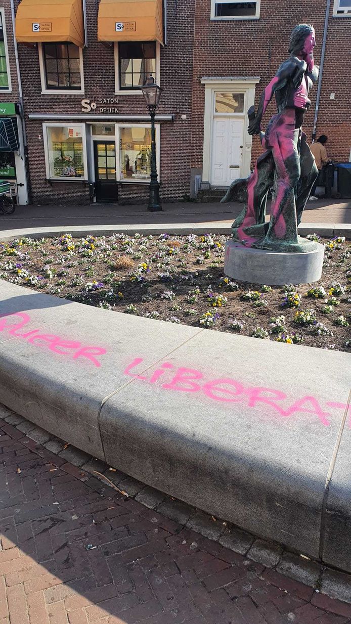 Rondom het standbeeld zijn verschillende leuzen geschreven met roze verf
