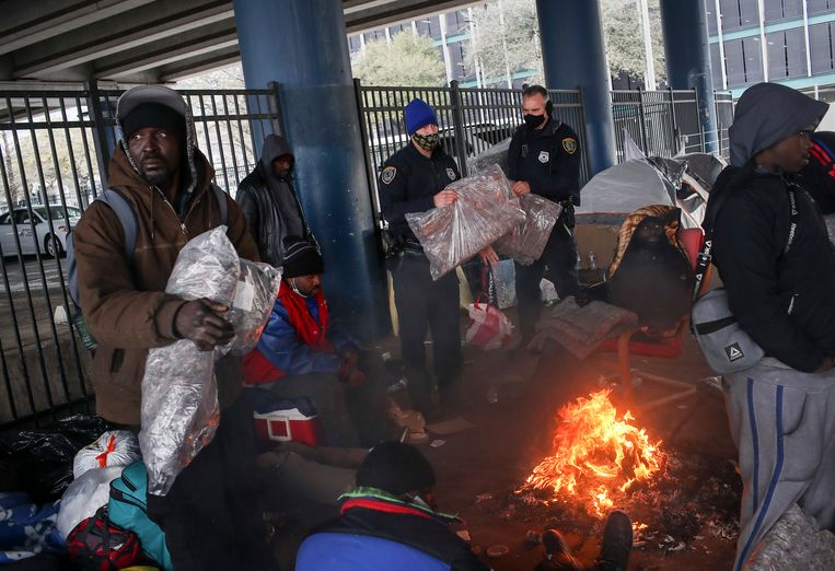 Politieagenten delen dekens uit aan dak- en thuislozen in Houston. Beeld AP
