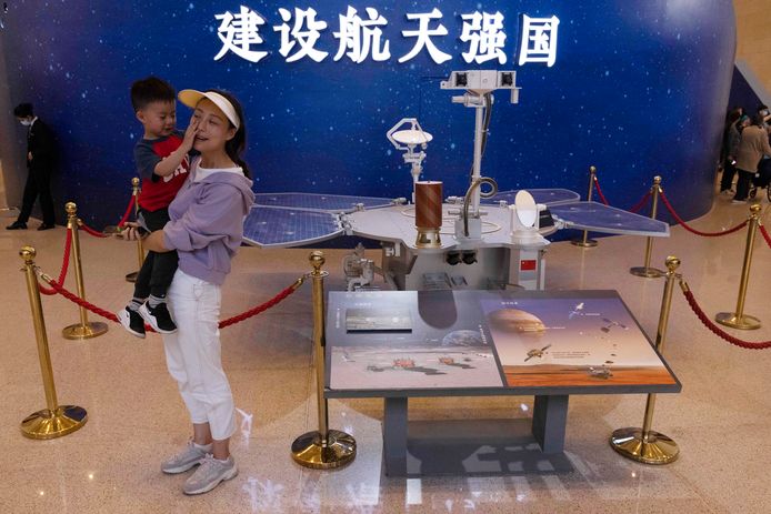 Bezoekers poseren bij een model van de Chinese Mars-rover Zhurong in het Nationaal Museum van Peking.