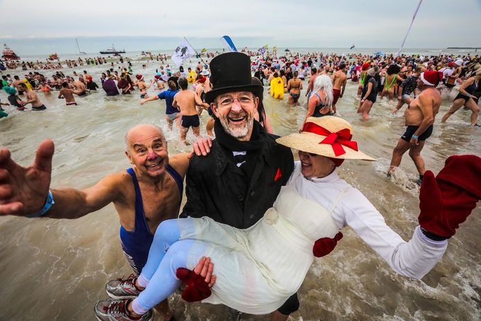In een goedkope versie van hun trouwkleren, maar daarom niet minder gemeend: Oostendenaars Walter Tyteca en Vera Boels verwarmen zich aan elkaar in de Noordzee.
