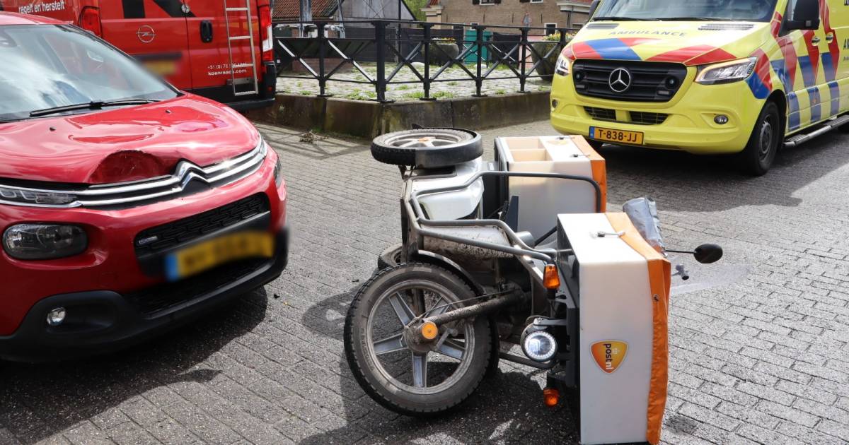 Postbezorgster valt hard op de weg door botsing met auto.