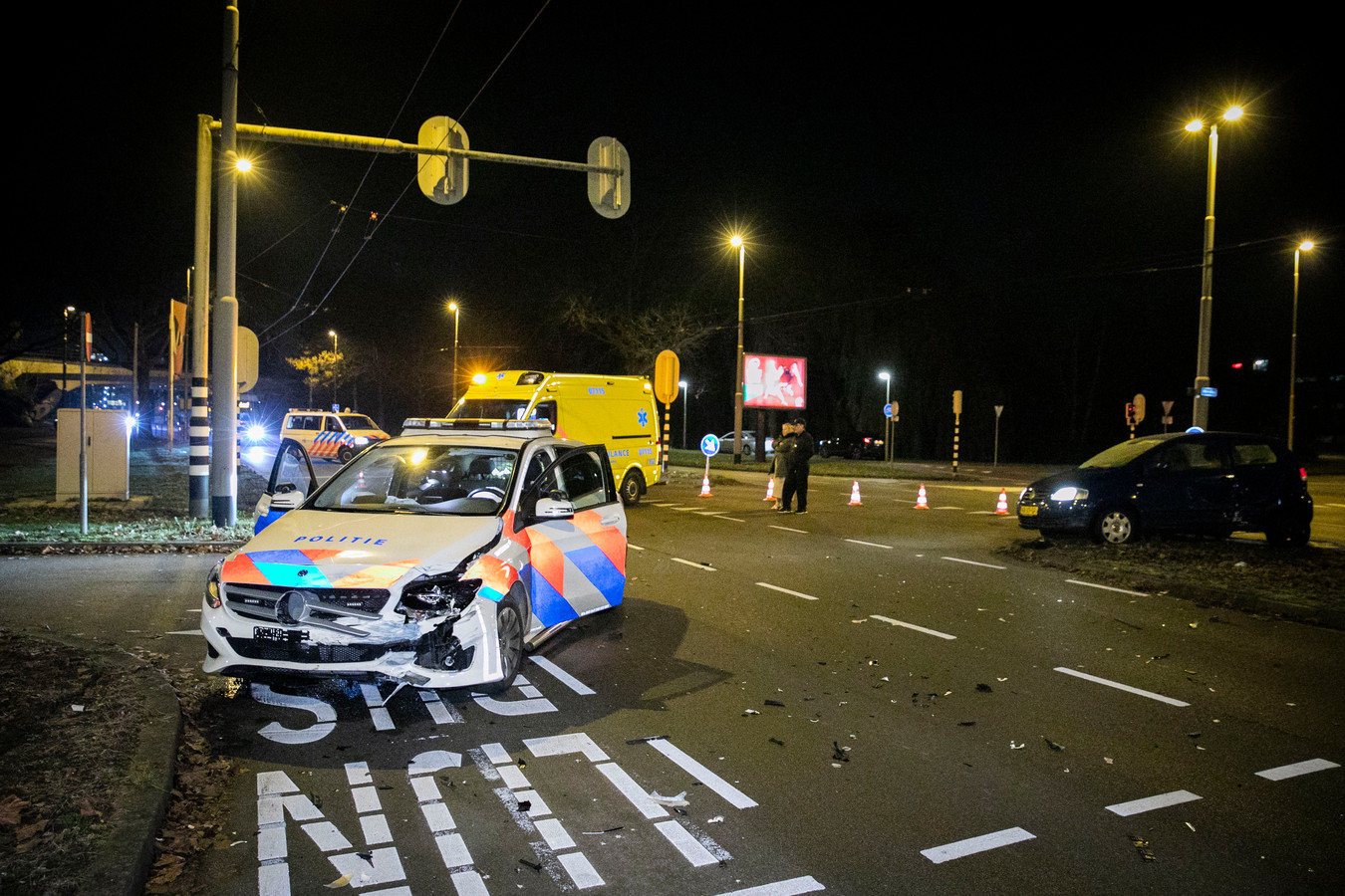 De gehavende politiewagen en de auto waarmee deze botste op weg naar een inzet.