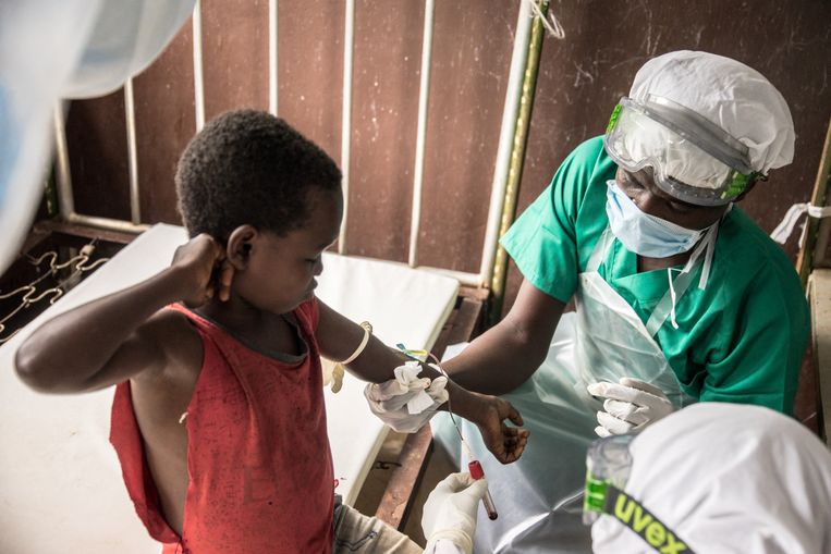 Een arts in de Centraal-Afrikaanse Republiek neemt een bloedstaal af van deze jongen, wiens hele familie besmet is met monkeypox. Beeld AFP
