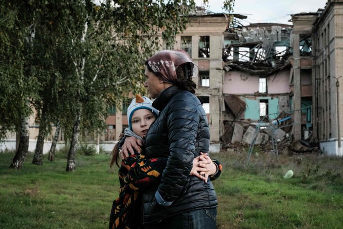 Olga Srednyakova (51), een alleenstaande moeder van acht kinderen, omhelst haar jongste dochter, Vera, terwijl de andere kinderen (buiten beeld) champions zoeken op de gronden van hun kapotgeschoten school in Konstantinovka in de Donetsk-regio in Oekraïne.