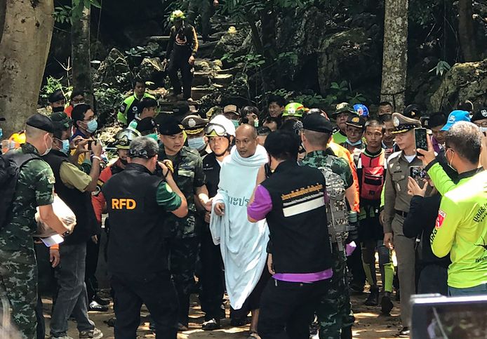 Reddingswerkers lopen samen met de 46-jarige monnik Phra Manas de Tham Phra Sai Ngam-grot uit nadat hij daar vier dagen had vastgezeten door overstromingen.
