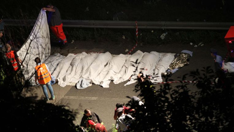 Reddingswerkers bedekken slachtoffers van het busongeluk in zuid-Italië. Beeld EPA