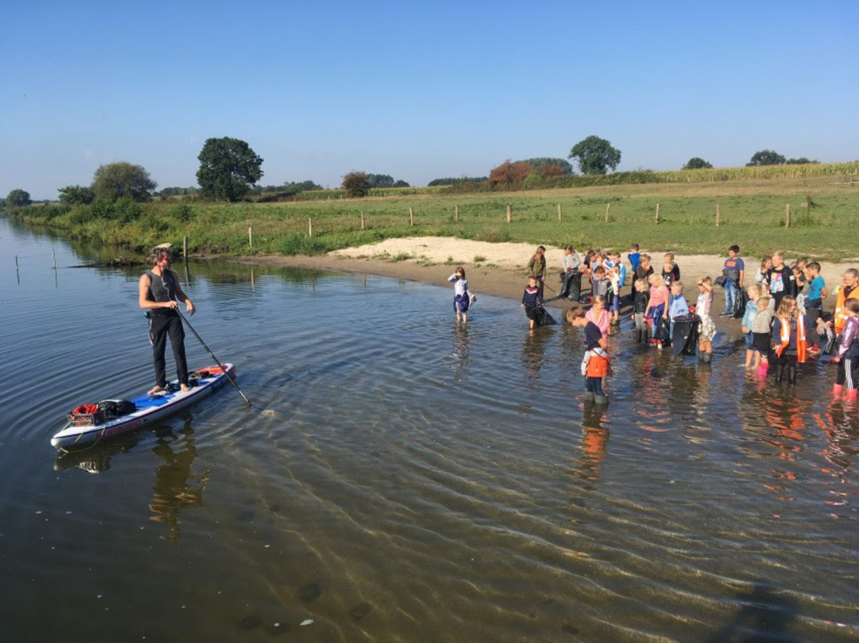 Plastic Soup Surfer Merijn Tinga ontmoet op de Maasover kinderen van een basisschool voor de actie Wakkere Wegwerpers. Beeld Botsmedia
