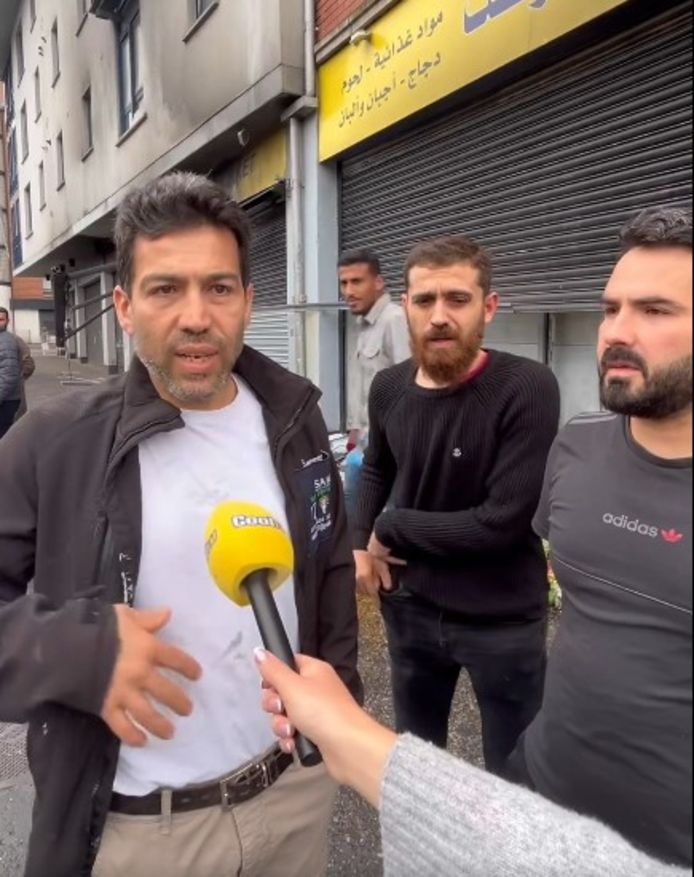 Abdelkader Al Alloush (R) met Sam Yousef van de Syrische gemeenschap in Belfast (L). Op de achtergrond helpen vrienden met het opruimen van het puin na de verwoesting van de supermarkt.