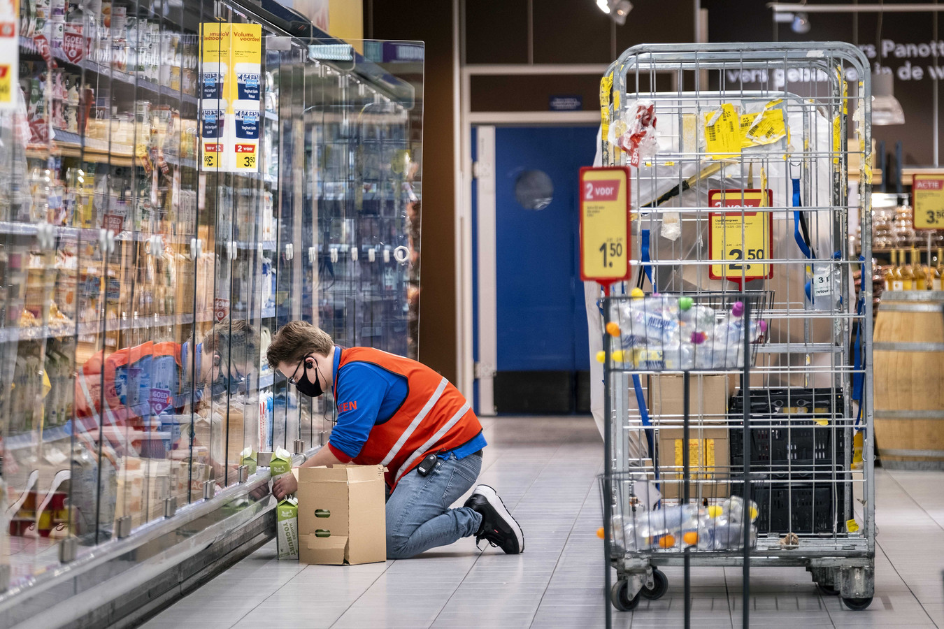 Een medewerker vult de schappen in supermarkt.