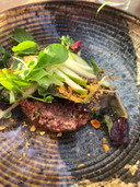 De steak tartaar met mosterdschuim, cornichon, eigeel en desemkrokant.