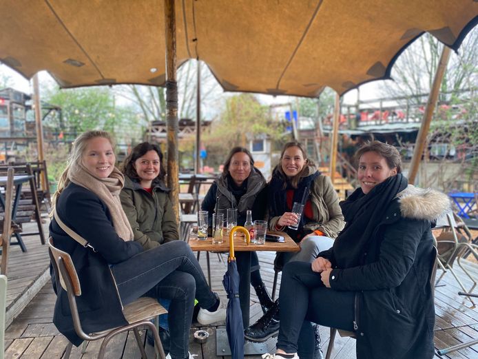 Vriendinnen Sofie, Lisa, Charlotte, Hanne en Nele genieten van het zonnetje in hun glas in zomerbar Bar Bricolage. De paraplu blijft binnen handbereik.