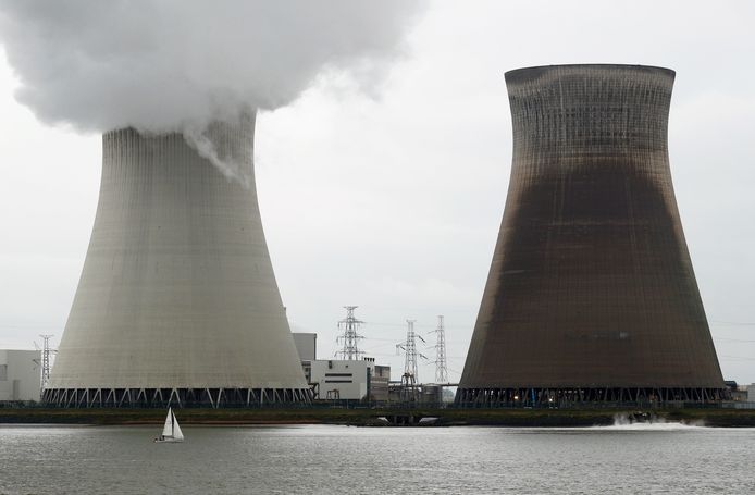 Een bootje vaart voor de koeltorens van de kerncentrale van Doel langs.