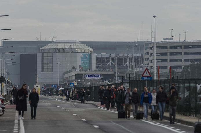 Na de bomaanslagen op Brussels Airport op 22 maart 2016 wandelen reizigers weg van de luchthaven. (Archieffoto)
