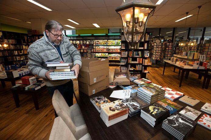 Hans van Gennep, eigenaar van boekhandel de Ganzenveer, pakt nieuwe boeken uit