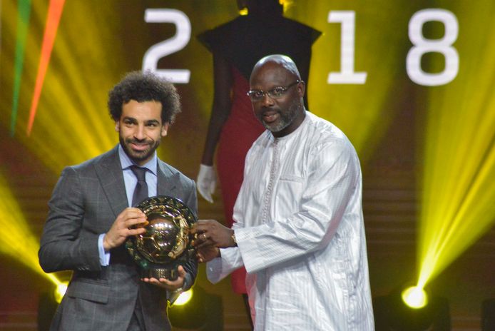 George Weah, president van Liberia en ex-topvoetballer, overhandigt Salah zijn trofee.