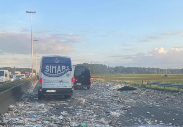 Brokstukken liggen verspreid over het wegdek.