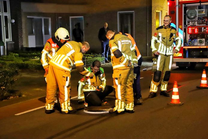 De brandweer meet met een sensor waarden uit de put.