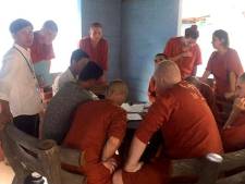 Feesttoeristen kaalgeschoren en in oranje pak in Cambodjaanse cel