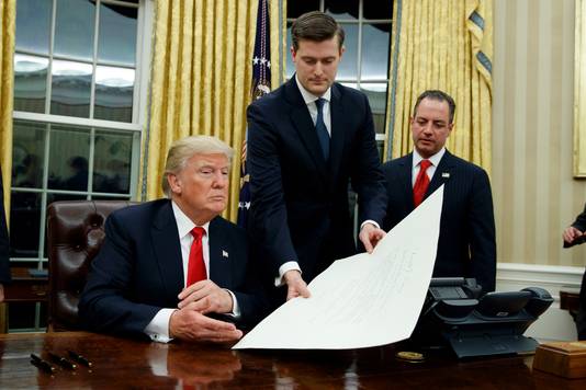 Rob Porter (m.), overhandigt Trump een document in het Witte Huis terwijl toenmalig stafchef Reince Priebus, ondertussen ook ontslagen, toekijkt.