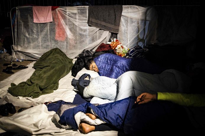 Asielzoekers die noodgedwongen buiten moeten slapen buiten het overbevolkte asielzoekerscentrum in Ter Apel. Archiefbeeld van afgelopen zomer.