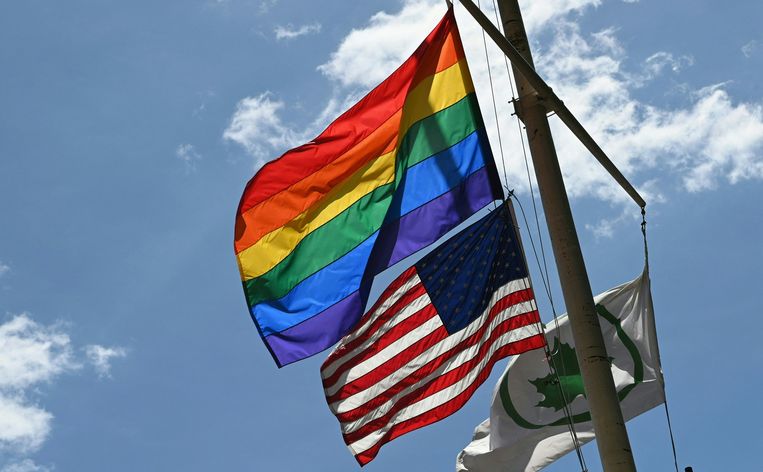 De regenboogvlag en de Amerikaanse vlag wapperen aan het Stonewall National Monument in New York. Beeld AFP