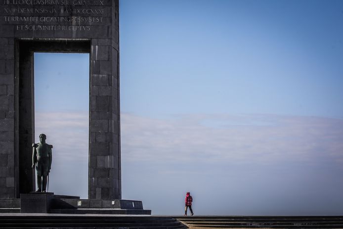 Een eenzame wandelaar op de lege esplanade in De Panne.