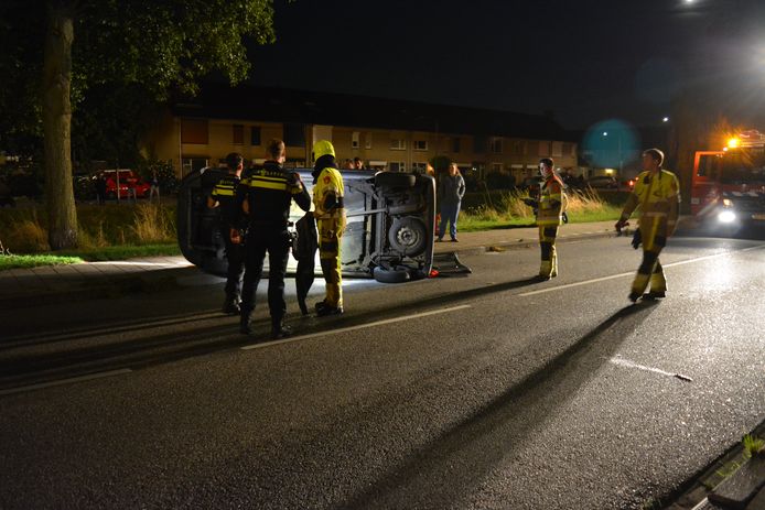 Hulpverleners en politieagenten bij de gecrashte auto op de Ackerbroekweg in Nijmegen.
