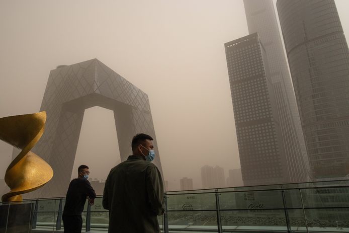 Mensen met mondmasker afgelopen weekend tijdens de zandstorm in Peking.