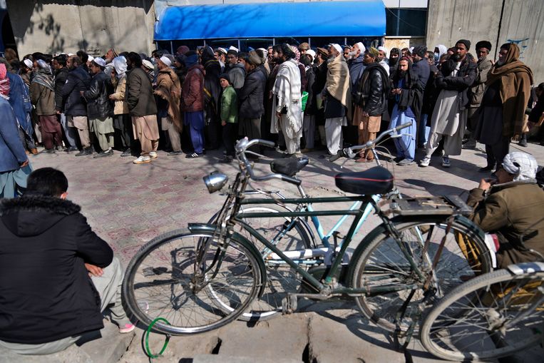 Afghanen staan in de rij voor een bank. Na de machtsovername van de Taliban sloten veel banken de deuren, uit angst voor een bankrun.  Beeld AP