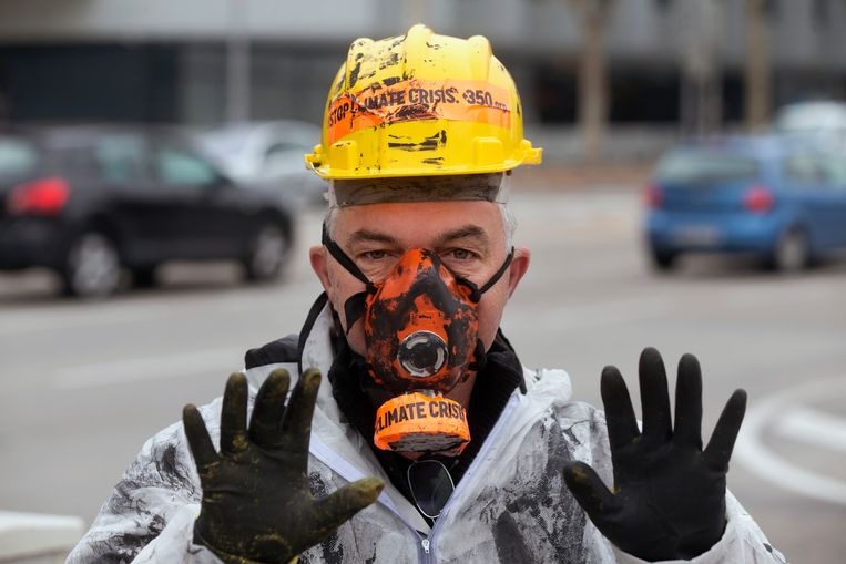 Een demonstrant voor het hoofdkantoor van oliegigant Repsol zondag in Madrid. Beeld AP
